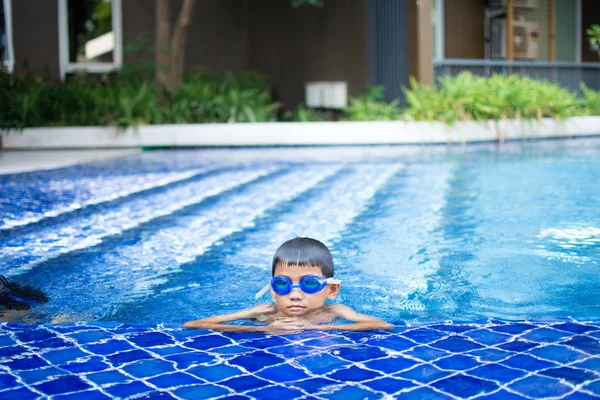 かわいい小さな男の子は スイミングプール 晴れた日とソフトフォーカスで幸せな遊びや水泳を感じます — ストック写真