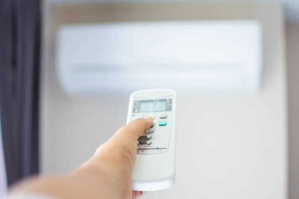 Human hand press on remote control of Air Conditioner with hot w — Stock Photo, Image