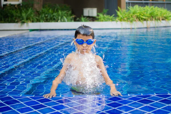 かわいい小さな男の子は スイミングプール 晴れた日とソフトフォーカスで幸せな遊びや水泳を感じます — ストック写真