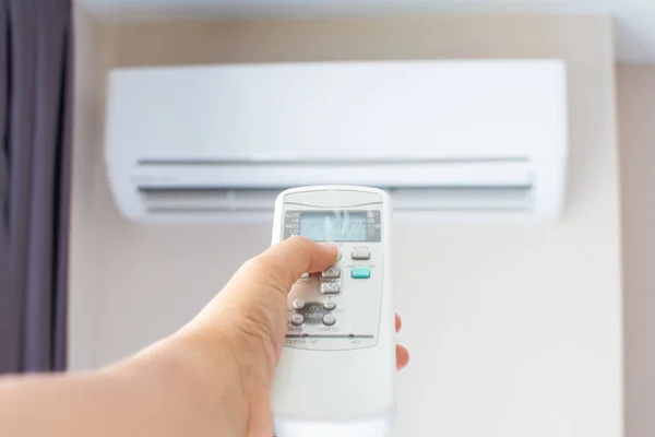 Human hand press on remote control of Air Conditioner with hot w — Stock Photo, Image