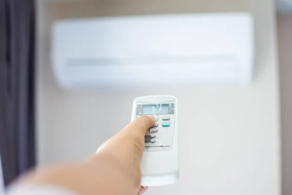 Human hand press on remote control of Air Conditioner with hot w — Stock Photo, Image