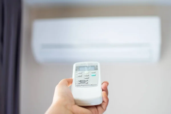 Human hand press on remote control of Air Conditioner with hot w — Stock Photo, Image