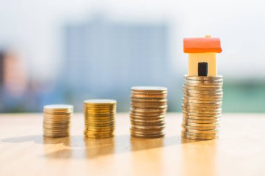 Tahta masaya para ve arka planı bulanık minyatür eve..