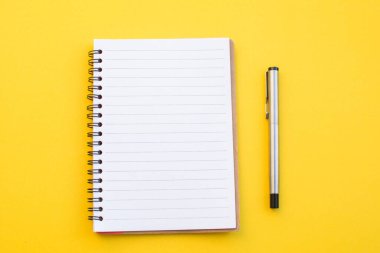 Okul konseptiyle sarı arkaplanda boş bir defter.