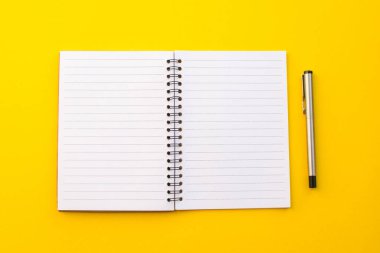 Okul konseptiyle sarı arkaplanda boş bir defter.