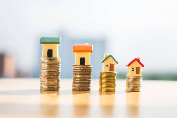 Tahta masaya para ve arka planı bulanık minyatür eve..