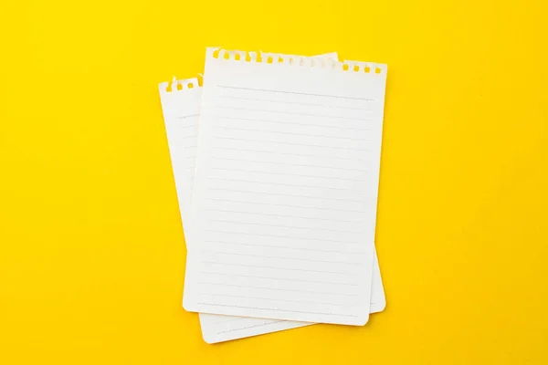 Okul konseptiyle sarı arkaplan üzerine boş defter kağıdı.