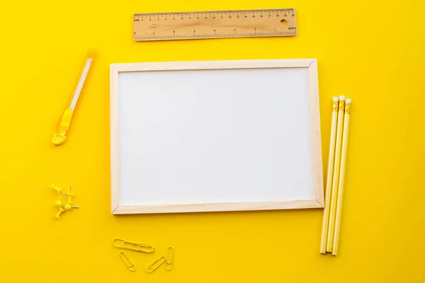 Kalem ve okul kavramına sahip sarı arkaplan üzerindeki beyaz kopya alanı.