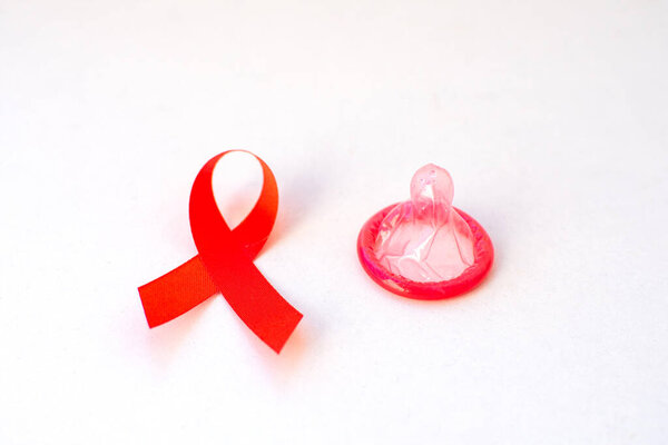 Red ribbon and condom World Aids day concept. 