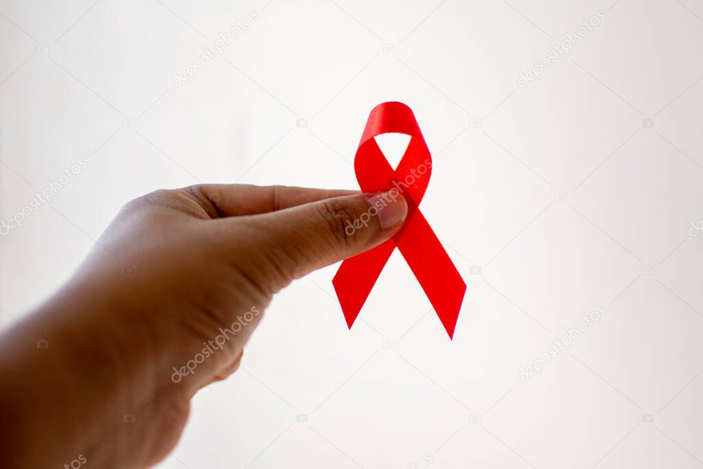 Red ribbon on hand with World Aids day concept. 