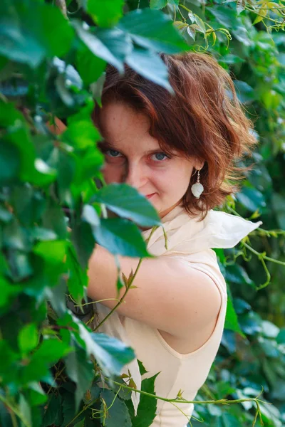 Schönes Mädchen Einem Hellbeigen Kleid Grünen Blättern Nahaufnahme — Stockfoto