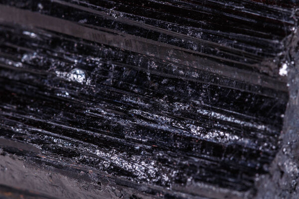 macro mineral stone sherle, schorl, black tourmaline on white background close-up