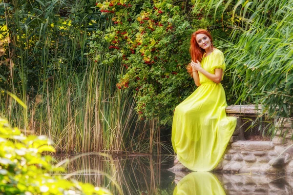 川の土手に黄色いドレスの美しい女の子をクローズ アップ — ストック写真