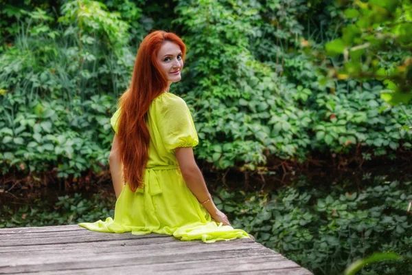 川の土手に黄色いドレスの美しい女の子をクローズ アップ — ストック写真