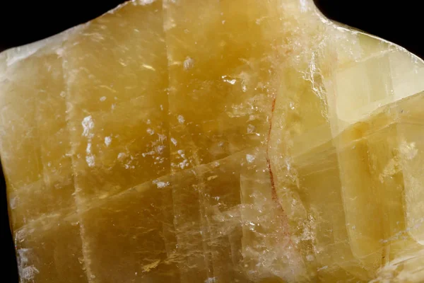 Macro mineral stone yellow Calcite on a black background close up