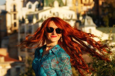 Bir huş bluz şehir yakın çekim arka plan üzerinde kırmızı saçlı güzel bir kız portresi