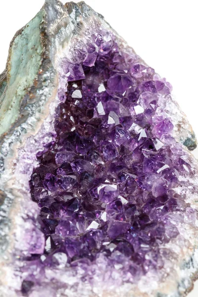 Macro Mineral Stone Amethysts in the rock on a white background close up