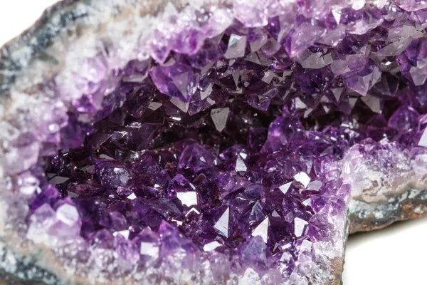 Macro Mineral Stone Amethysts in the rock on a white background close up