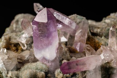 Macro mineral stone Amethyst crystals in rock on a black background close up clipart