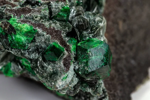 Macro stone garnet mineral, Uvarovite in rock on a white backgro — Stock Photo, Image