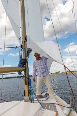 gök ve Wat karşı yelken altında bir teknede bir kap içinde denizci adam