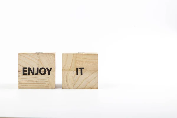 Los cubos de madera con la inscripción lo disfrutan sobre un fondo blanco —  Fotos de Stock