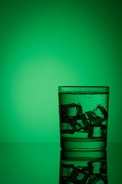 Mooi Glas Met Ijs Water Een Groene Achtergrond Van Dichtbij — Stockfoto