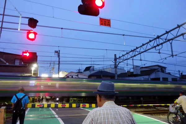 Люди Ожидающие Проезда Железнодорожного Переезда Вечером — стоковое фото