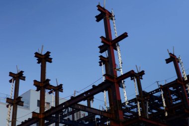 Gökyüzüne yükselen bir binanın çelik çerçevesinin montajı devam ediyor