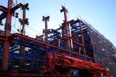 Gökyüzüne yükselen bir binanın çelik çerçevesinin montajı devam ediyor