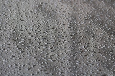 Bahçe masa yüzeyinin yansıtan üzerinde yağmur damlaları