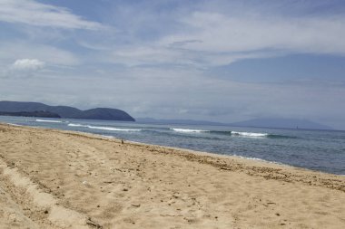 Kumlu plaj ve su ufukta görünümü