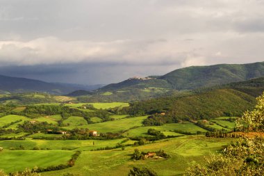 İtalyan Toskana Volterra şehir alanları ve tek yalnız ev ya da küçük köylerde yanında tepelik kırsal dağ manzarası