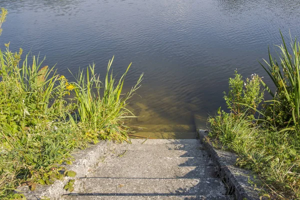 concrete staircase leads to water of dam