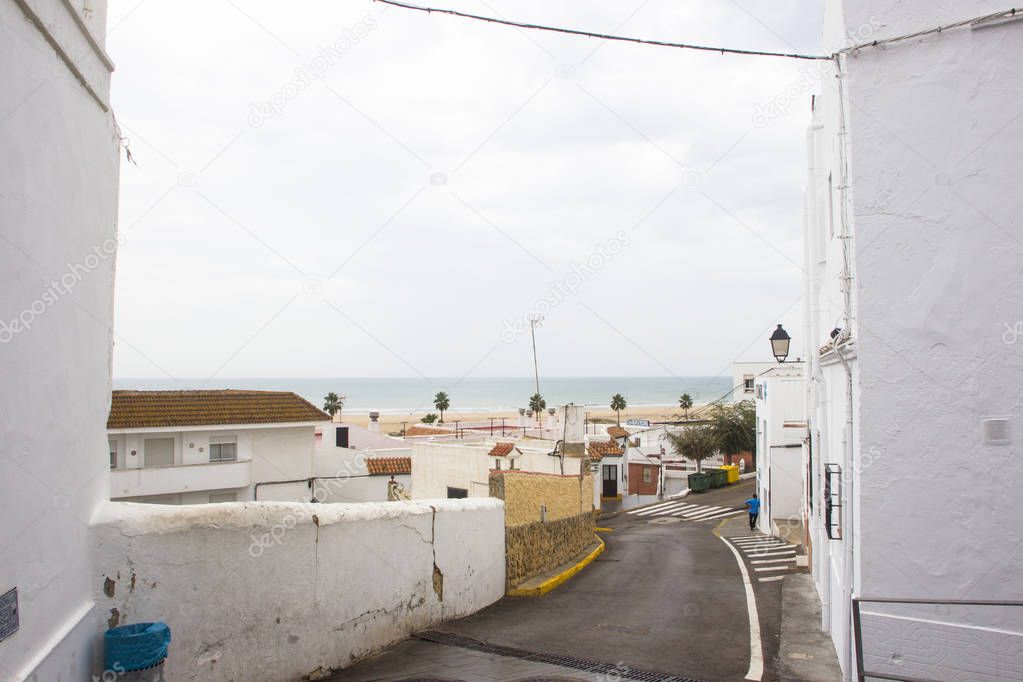 View to sea between Spanish houses in white city of Conil de la Frontera on Costa del luz