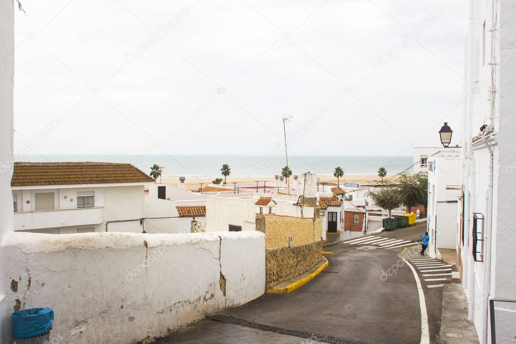 View to sea between Spanish houses in white city of Conil de la Frontera on Costa del luz