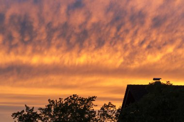 Parlayan kırmızı akşam bulutlarıyla görkemli gün batımı