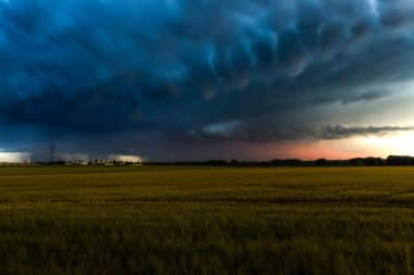 Bulutlu gökyüzü ve Augsburg yakınlarındaki Inningen manzaralı buğday tarlaları üzerinde fırtına atmosferi
