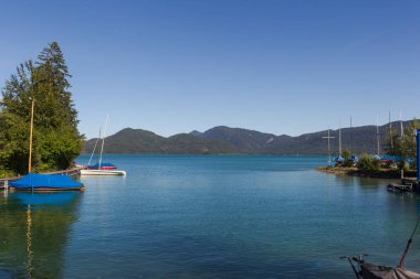 Yelkenli tekneler ve güneşli bir yaz gününde Bavyera 'daki Walchensee limanı manzarası