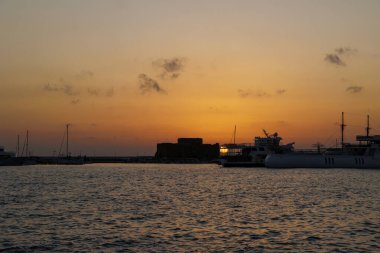 Paphos Kalesi ve limanı üzerinde altın gün batımı, Kıbrıs, 23.11. 2024