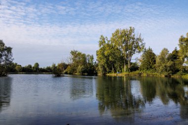 Ağaç yansımalı geniş göl manzarası Almanya, Mering, 17 Eylül 2025