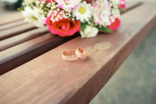 Cincin pernikahan emas di karangan bunga mawar — Stok Foto