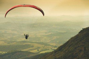 Yamaçparaşütü gelemeyeceğiz de Caldas, Minas Gerais yeşil dağların üzerinde güzel güneşli gökyüzü üzerinde uçan
