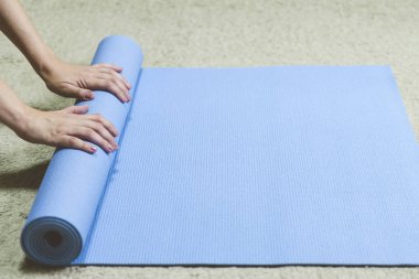 Mavi yogamat inişli çıkışlı siyah giysili kafkas kadın