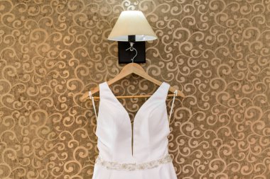 Doku ile duvarda asılı gelinlik 