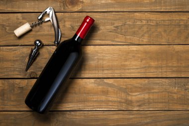 Bir şişe şarap tirbuşon ve tirbuşon ahşap arka plan üzerinde. Kopya alanı ile üstten görünüm.