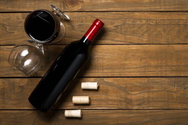 Bir şişe şarap cam ve ahşap arka plan tarihinde mantarlar. Kopya alanı ile üstten görünüm.