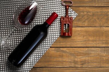 Bir şişe şarap kadehi ve tirbuşon ahşap arka plan üzerinde. Kopya alanı ile üstten görünüm.