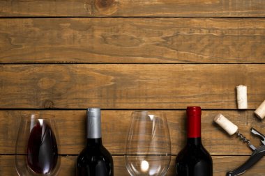 Bardak şarap şişesi mantarlar ve açacağı ahşap arka plan üzerinde. Kopya alanı ile üstten görünüm.