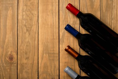 Birkaç şişe şarap ahşap arka plan üzerinde. Kopya alanı ile üstten görünüm.
